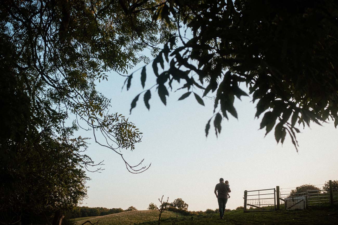 Father carries daughter across field in Derbyshire